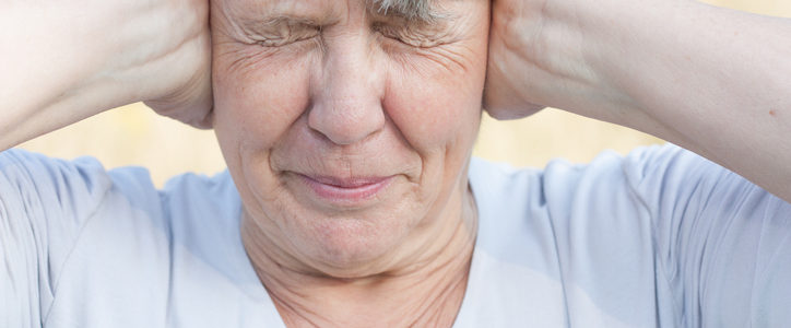 senior woman covering ears