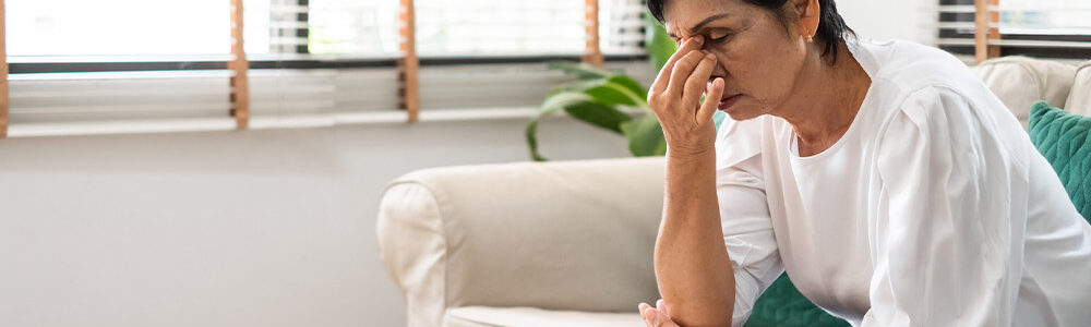 Woman pinching nose in stressful way.