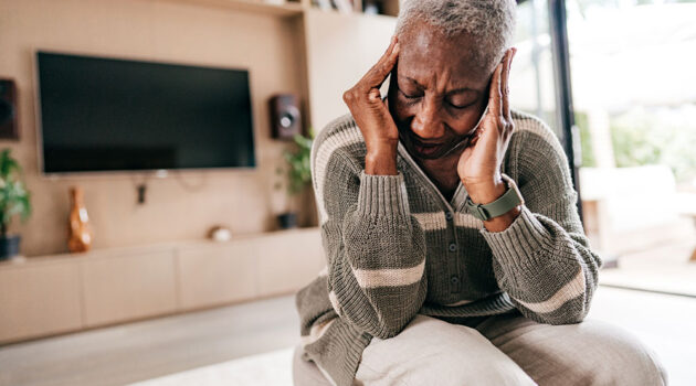 Woman holding head in discomfort.