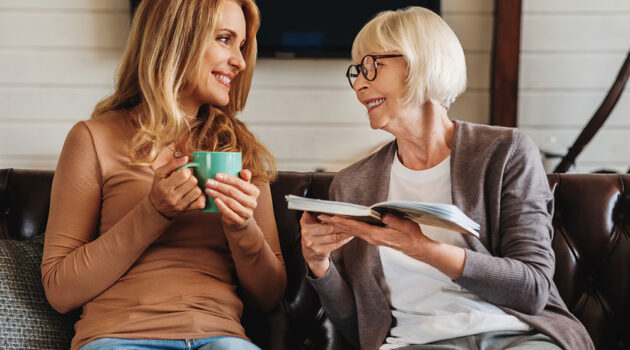 Two women sitting next two each other talking