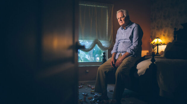 Man sitting on edge of bed.