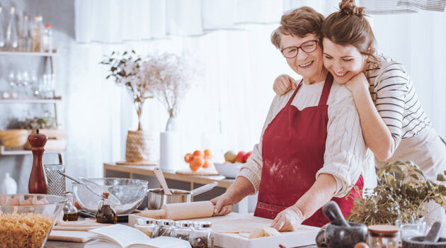 grandmother and granddaughter cooking in kitchen.