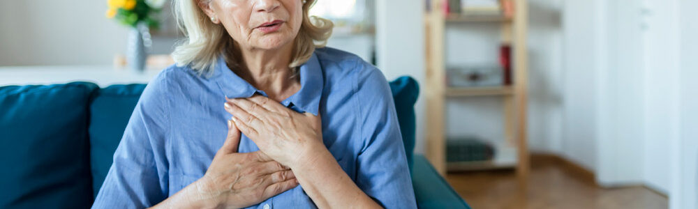 Older woman clutching chest.