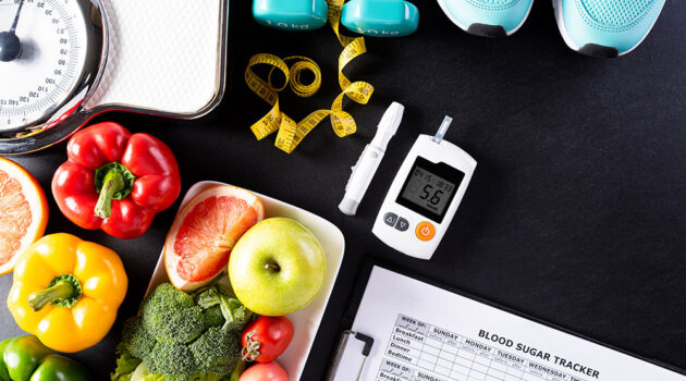 Fruit and vegetables on a table nest to diabetes reader.