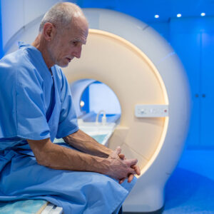 Man sitting on bench of MRI machine.