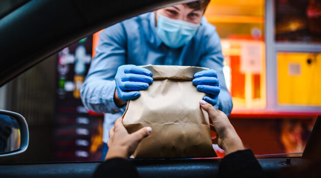 Woman picking up food from restaurant.