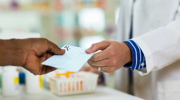 Doctor handing patient prescription slip.