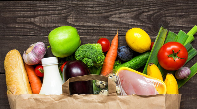 Assortment of vegetable spilling out of bag onto a table top.