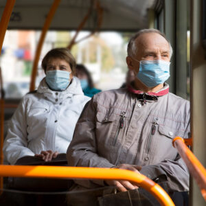 Masked man and woman on bus.