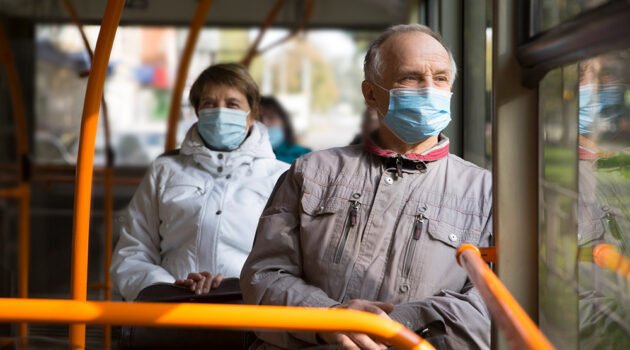 Masked man and woman on bus.