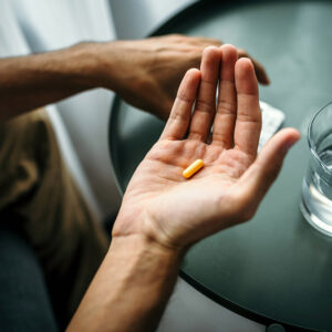 Person loooking at pill in hand.