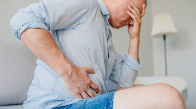 Man holding stomach in pain.