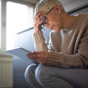 Woman reading a paper looking stressed.