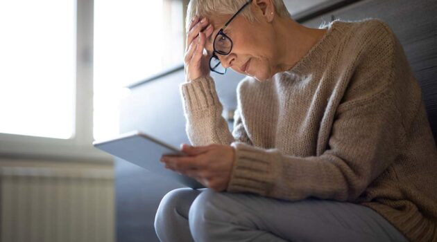 Woman reading a paper looking stressed.