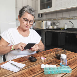 lady sitting at table sorting pills.