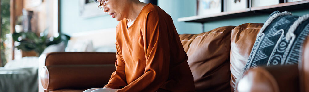 Person sitting on a couch looking down.