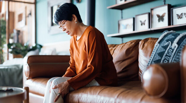 Person sitting on a couch looking down.