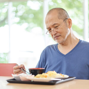 Man sitting in front of food at a table.