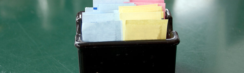 Artificial sweetener packets in black container includes yellow sucralose package