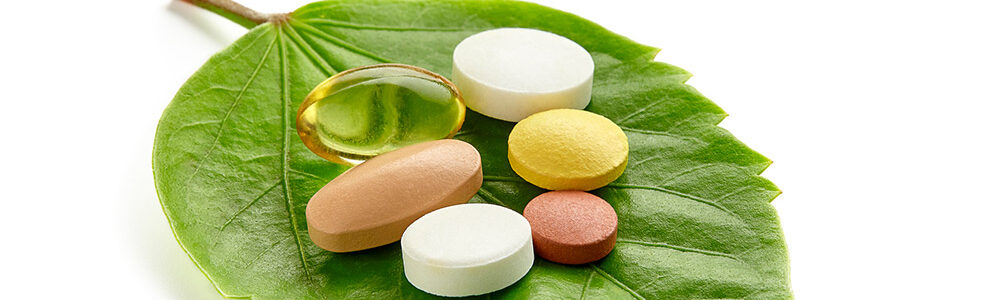 Supplements on a leaf to illustrate that there are natural alternatives to drugs.